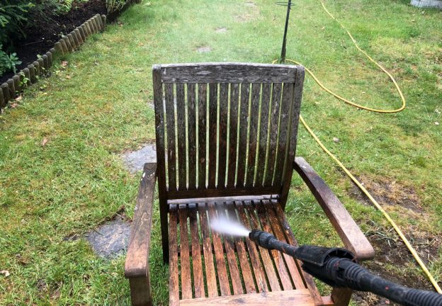 High power pressure washing a dirty garden chair