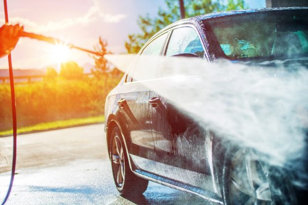 Pressure washing a car in the sun