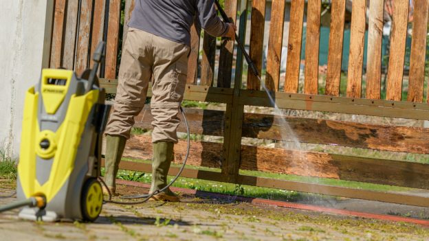 Karcher pressure washer being used on a wooden fence