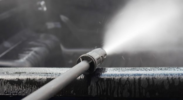 A pressure washer leaning on a wall