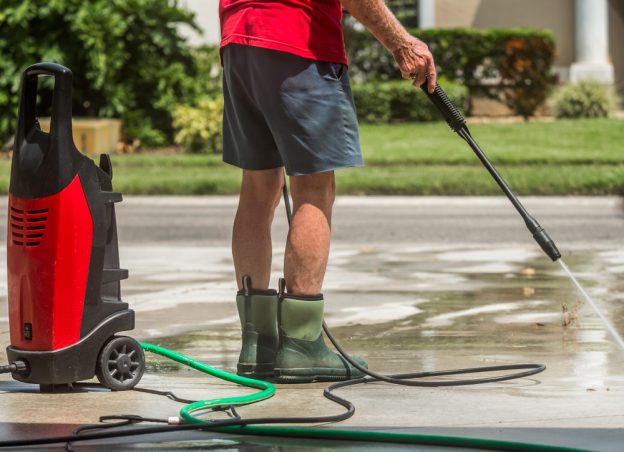 Man in wellies holding a pressure washer